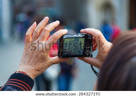 woman holding a camera to take a photo at the Grand Place in Brussels, Belgium