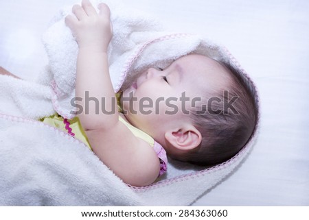 Baby playing with towel.Baby sleeping with sleep problems in pretty dim., a bright face, high forehead rhyme, big eyes, long eyelashes, white skin, baby loves watching her while I took pictures.