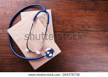 Stethoscope on books on wooden background