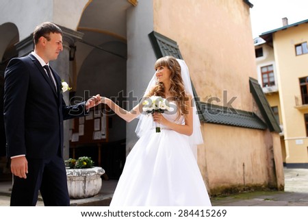 happy joyful young blond bride and groom on the background excellent sunny architecture