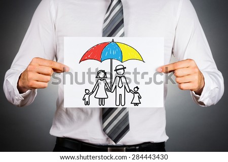 Family insurance concept. Businessman holding paper with drawing of a family under the umbrella. 