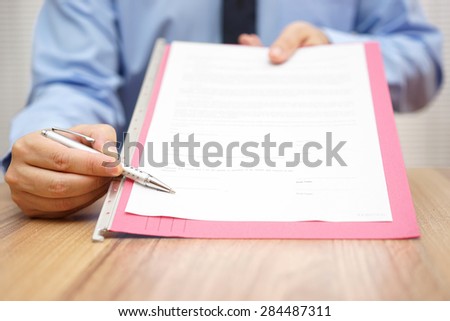 manager is showing where to sign a legal document