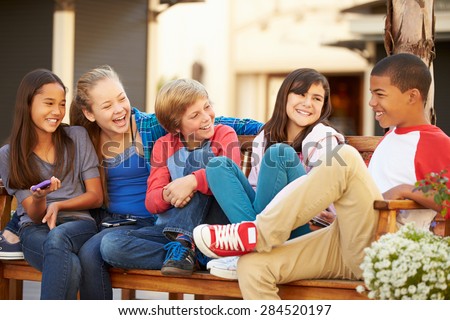 Group Of Children Sitting On Bench In Mall Royalty-Free Stock Photo #284520197