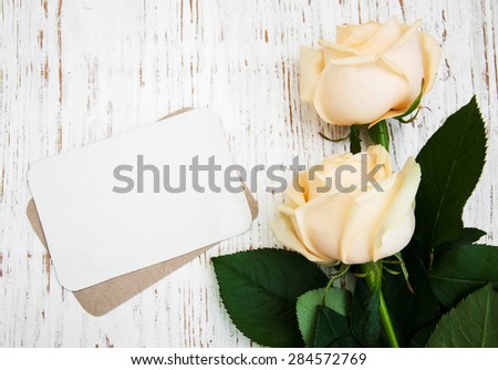 Roses with a card on a old wooden background