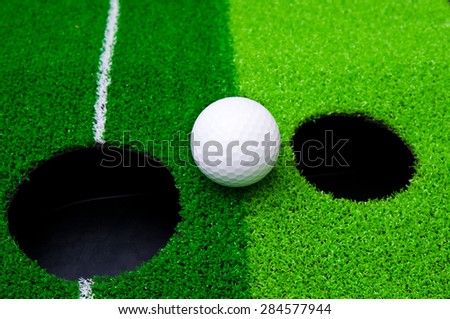 White golf ball on green grass 