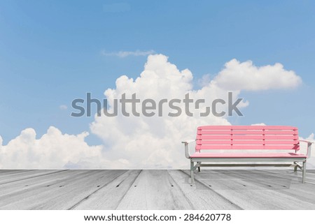 bench on wooden sidewalk with cloud and sky background