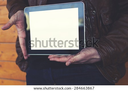Cropped image stylish young man showing you a digital tablet with blank copy space for your text message or content against wooden background, male student holding touch pad with empty template screen