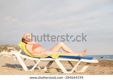 Woman lying on the sun bed on the beach