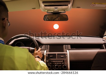 people driving car in sunset