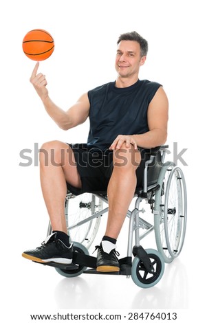 Disabled Basketball Player On Wheelchair Spinning Ball On His Finger Over White Background