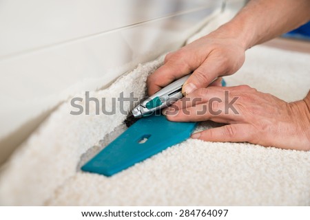 Close-up Of A Craftsman Cutting Carpet With Cutter Royalty-Free Stock Photo #284764097