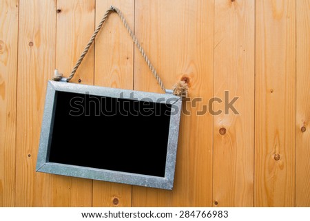 Black blank board on wooden door.