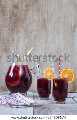 Refreshing sangria with fruits lemon, lime, orange, grapefruit with ice over wooden background