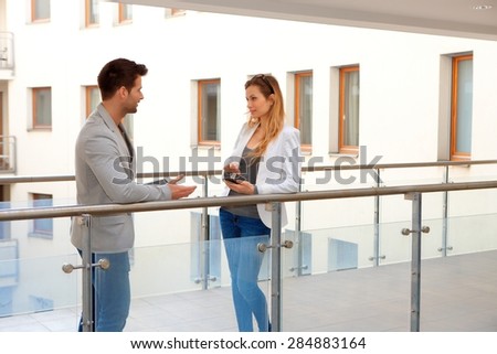 Business partners talking in corridor of apartment house.