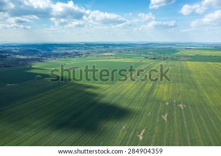 Aerial view of the large green field in spring season
