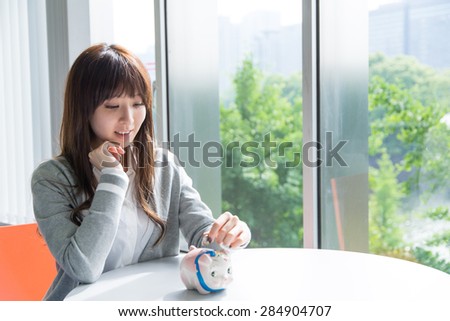 Asian woman with piggy bank