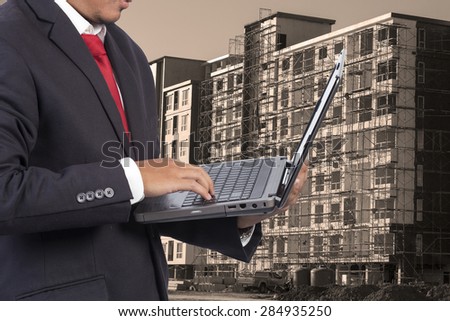 engineer holding laptop for workers security on contruction background