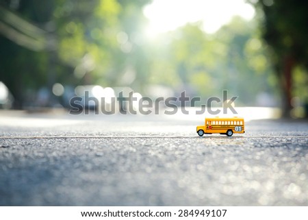 Yellow school bus toy model the road crossing.Shallow depth of field composition and  afternoon scene. Royalty-Free Stock Photo #284949107
