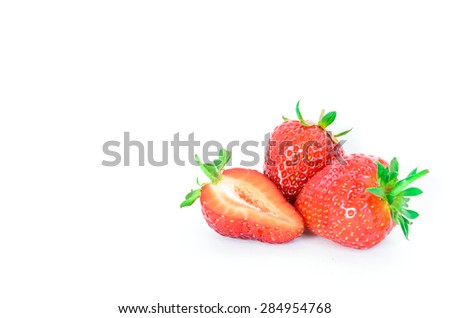 Two fresh and juicy ripe strawberries and a slice cut isolated on a white background. They are organically grown in Puyallup, Washington State, USA. Copy space.