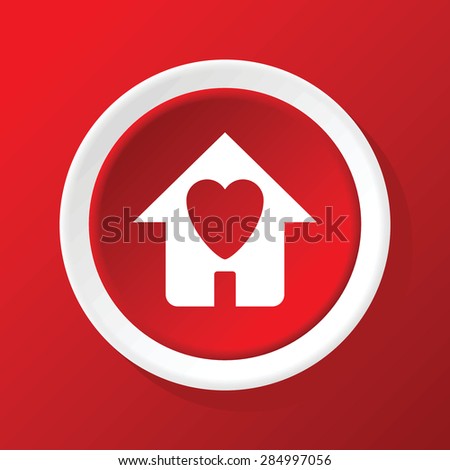 Round white icon with image of house with heart, on red background