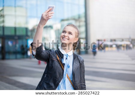 Joyful woman taking picture in city center