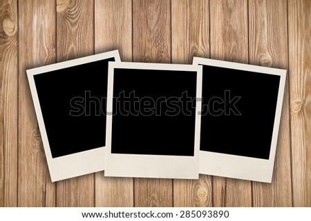 Three blank images on a wooden background
