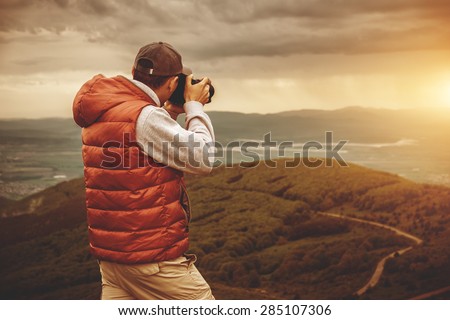 Photographer is taking a picture of  sunset in mountains