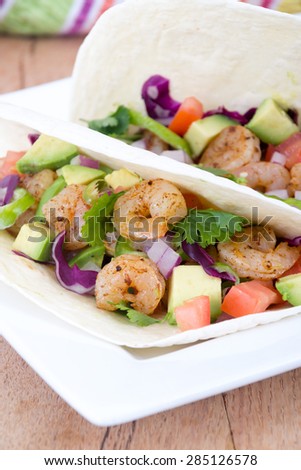 High resolution two spicy shrimp taco with avocado, tomato and red onion cilantro
