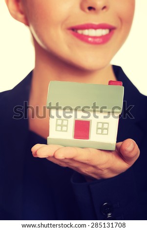 Businesswoman holding small model house