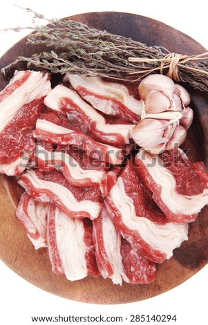 raw ribs with thyme and garlic on wooden isolated over white background