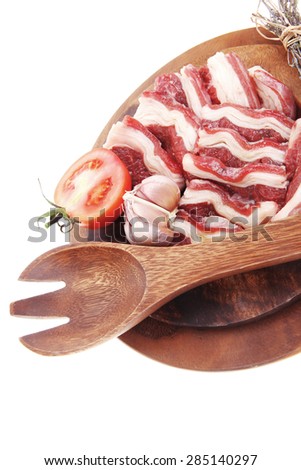 raw beef asado ribs with thyme and tomatoes on wooden board isolated over white background