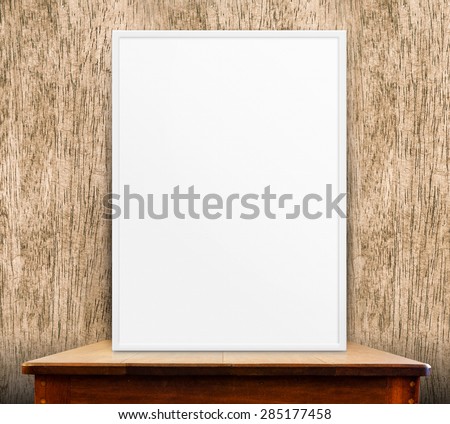 Empty white frame on wooden table at wood wall in background,Mock up for adding your design,