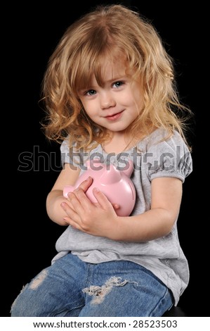 Young girl holding piggy bank isolated over a black background