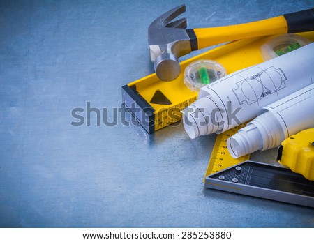 Hammer measuring line construction plans and level square ruler on industrial metallic background maintenance concept.