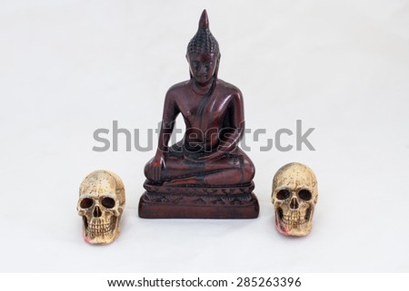 the buddha image and two skull on white background