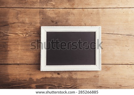 White picture frame on wooden floor background.