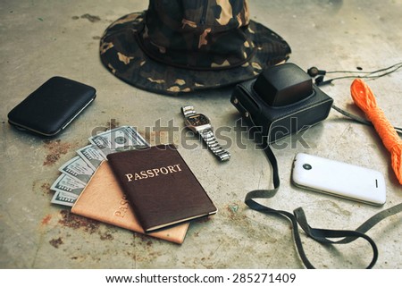 Concept turism.Items include an old photo camera, passport, wallet with currency, hat,  and smartphone