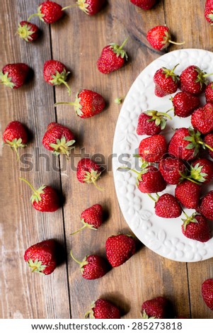 organic fresh sweet strawberries as a seasonal breakfast in the morning right from farmers market on dark wood table background decorated in rustic style
