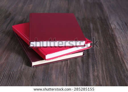 Three colorful books on wooden background