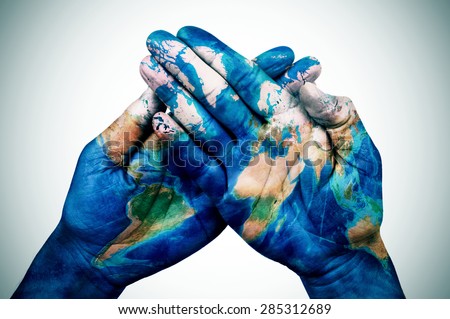 the hands of a young man put together patterned with a world map (furnished by NASA), slight vignette added Royalty-Free Stock Photo #285312689