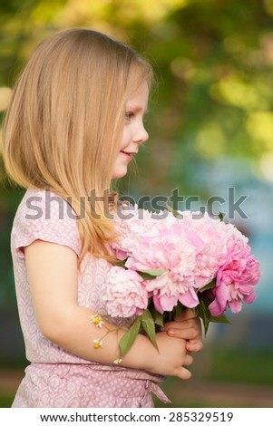 beautiful baby girl with pink flowers outdoors. Little girl 2-3 year old