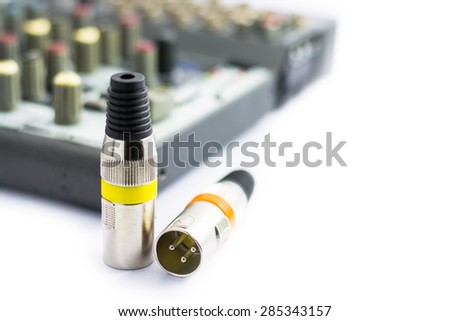 XLR jack with male and female plug and mixer on white background.