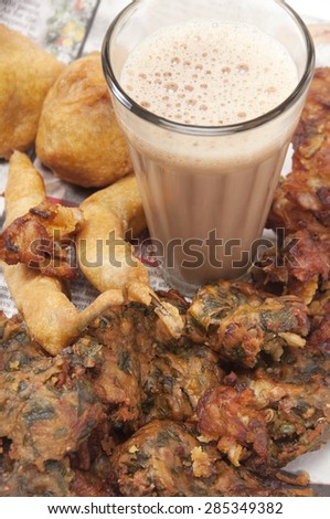 Close-up of chai with pakoras , bhajiyas and fried potato balls