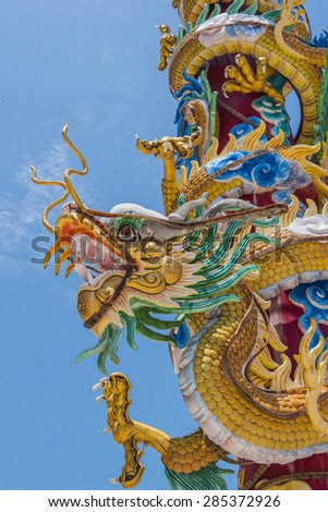Colorful dragon statue on pole with blue sky background
