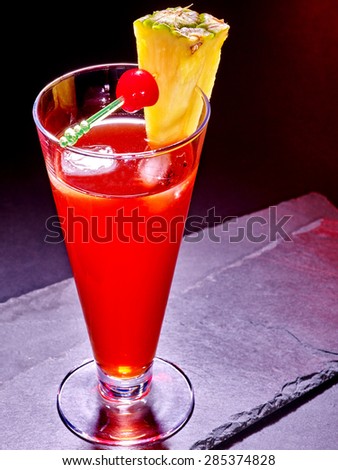 Red  drink  with cherry and pineapple in highball glass . Cocktail card 63