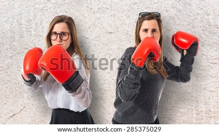 Twin sisters with boxing gloves over textured background