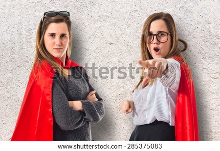 Twin sisters dressed like superhero over textured background