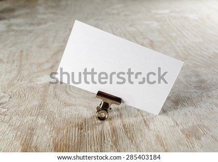 Photo of blank business card with soft shadow on light wooden background. Mock-up for branding identity. 
