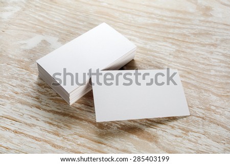 Photo of blank business cards with soft shadows on light wooden background. For design presentations and portfolios. Royalty-Free Stock Photo #285403199