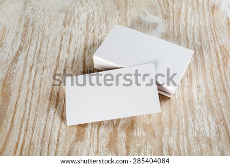 Blank business cards with soft shadows on light wooden background. Template for ID.